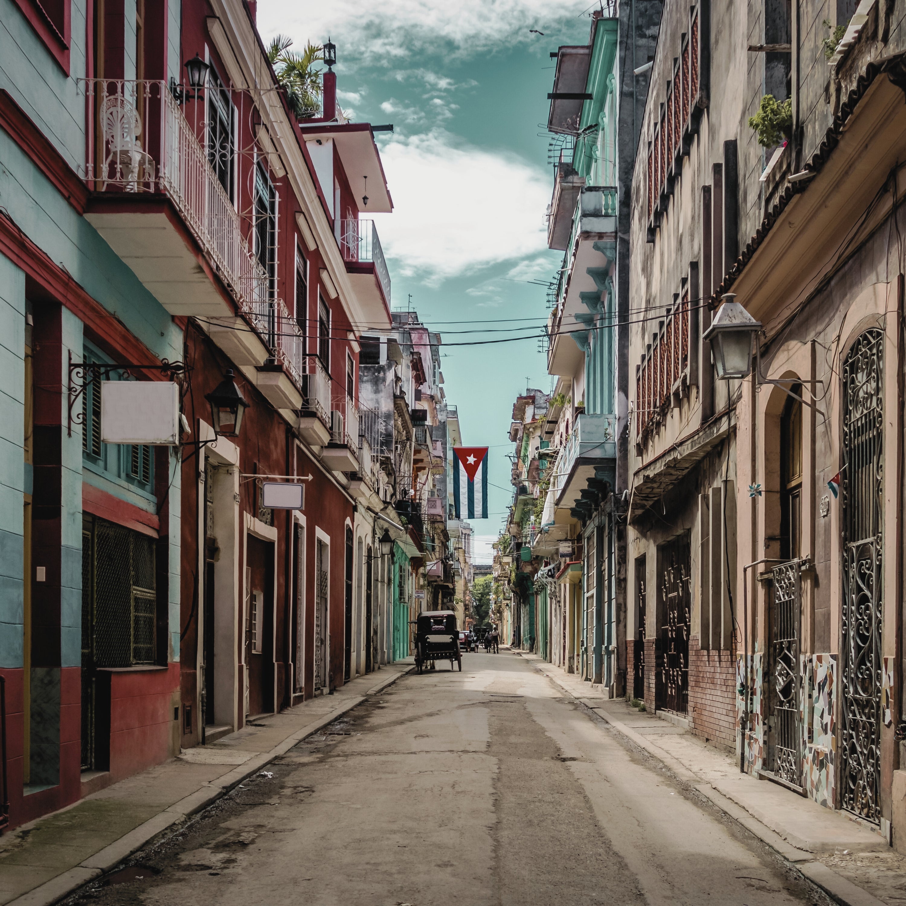 A narrow street of faded colonial facades in Havana, the inspiration for LUMIRA Cuban Tobacco